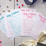 baby prediction cards laid out on a table next to a bow.