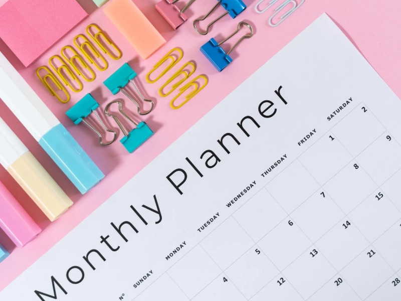 Monthly planner next to stationery.
